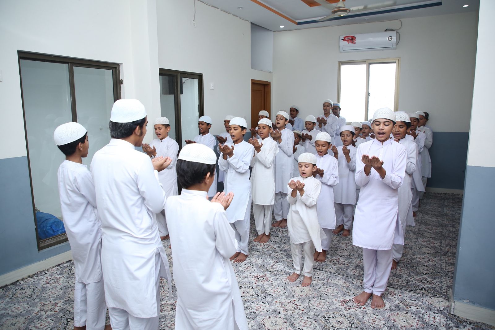 Hifz students raising their hands in dua